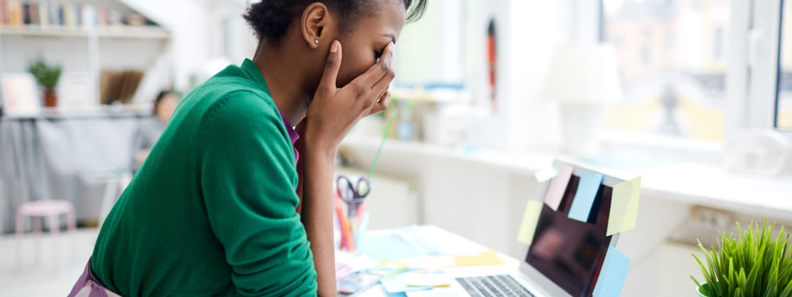 Older people were more likely to rate their stress as healthy, 39% of younger workers said their stress levels were unhealthy. Photo of worker feeling stressed at their desk.